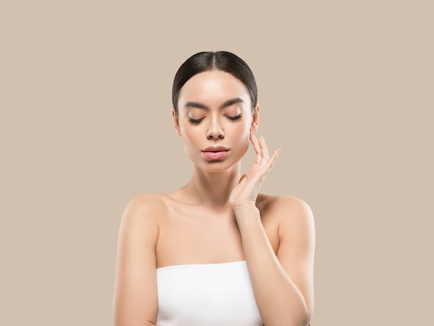 Asia woman beauty face body portrait touching her face healthy skin. Color background. Brown