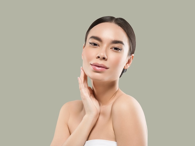 Asia woman beauty face body portrait touching her face healthy skin. Color background. Green