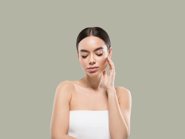 Asia woman beauty face body portrait touching her face healthy skin. Color background. Green