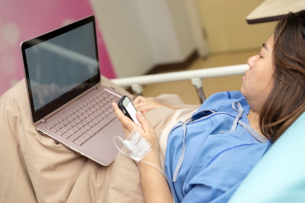 병원에서 노트북을 사용하는 아시아 여성 환자
