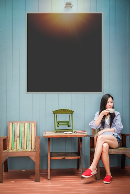 Asia woman sitting on the chair and drinking coffee at coffee shop during her vacation.