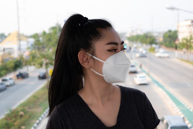 Asia woman standing putting on a respirator N95 mask