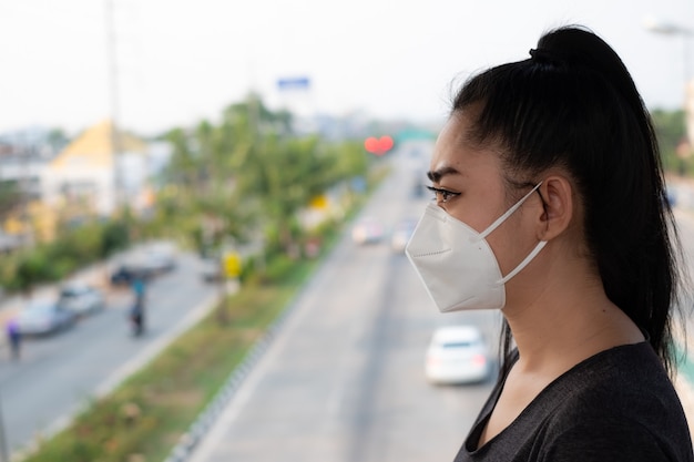 Asia woman standing putting on a respirator N95 mask