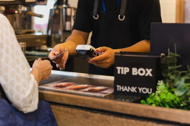 Photo asia woman use cashless wifi paywave scan on card reader in coffee shop