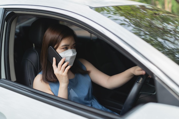 Asia woman using mobile phone while driving woman is calling insurance or someone to help when the car breaks down or has an accident