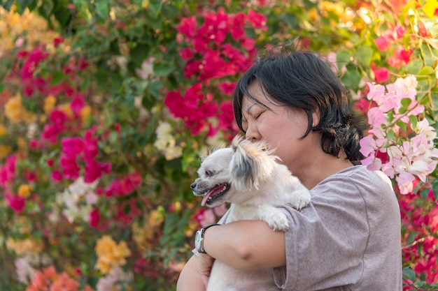 アジアの女性と犬の幸せな笑顔の抱擁