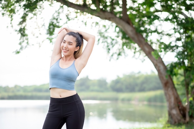 Asia women listen to music during a workout at the park.