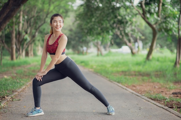 Asia women listen to music during a workout at the park.