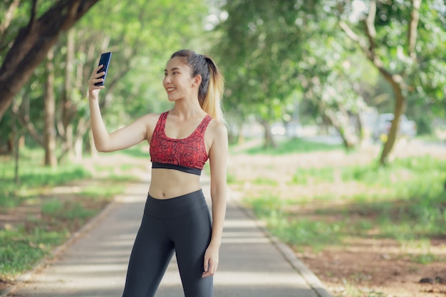 Asia women listen to music during a workout at the park.