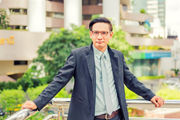 Asia young business man in front of the modern building in downtown 