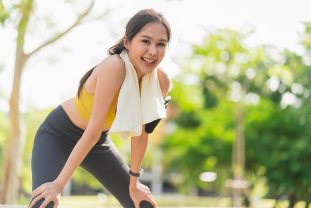 写真 公園の庭でのランニングセッションの後、アジアのアクティブな女性ランナーのトレーニングが腰をかがめて息を呑む朝の運動ライフスタイルで走った後に休憩するスポーツの女性女性