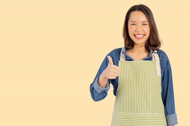 아시아 성인 여자 (주부) 앞치마를 입고 엄지 손가락 최대 배경에 고립