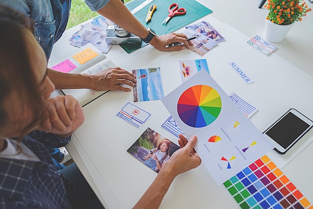 Foto gruppo start-up creativo del progettista asiatico di pubblicità che discute le idee in ufficio.