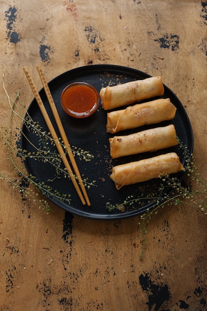 Asian appetizer roll with vegetables and sauce.