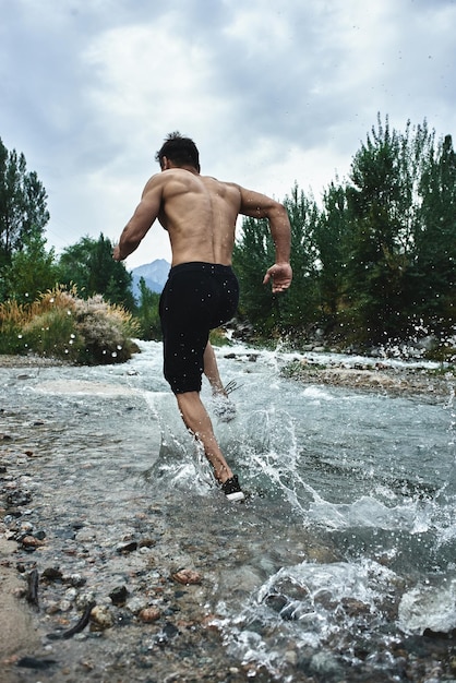 Asian athlete on a morning run on the river, Kazakh jogger in nature close-up