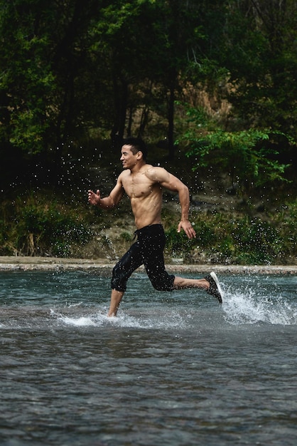 Asian athlete on a morning run on the river, Kazakh jogger in nature close-up