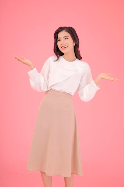 Asian attractive beautiful young woman with hand gesture showing with finger on the copy space isolated on background