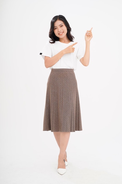 Asian attractive beautiful young woman with hand gesture showing with finger on the copy space isolated on background