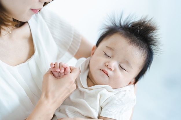 밝은 방에서 껴안는 아시아 아기