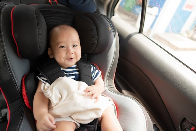 Foto bambino asiatico nel seggiolino auto