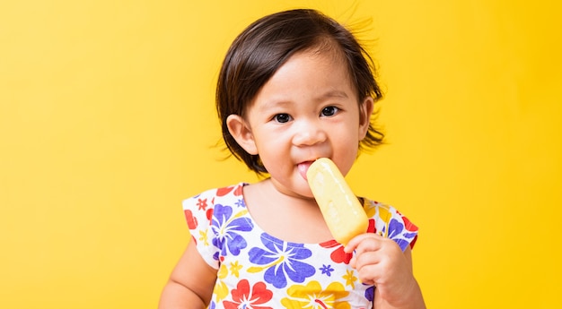 アジアの赤ちゃん女の子魅力的なアイスクリームを食べる