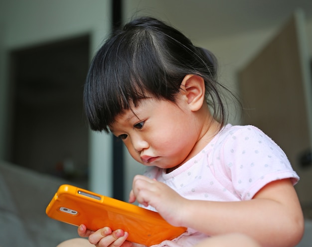 Asian baby girl playing a smartphone