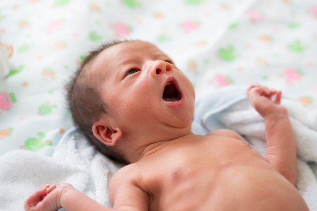 Asian baby yawning after bath