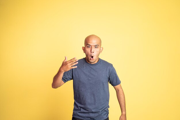 Asian bald man opening his mouth with spiciness expression