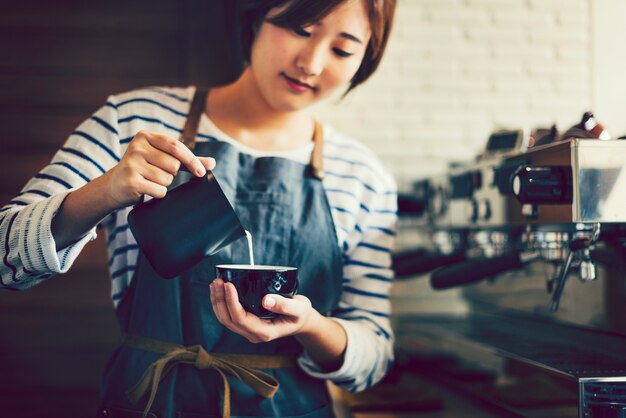 Asian barista creating latte art