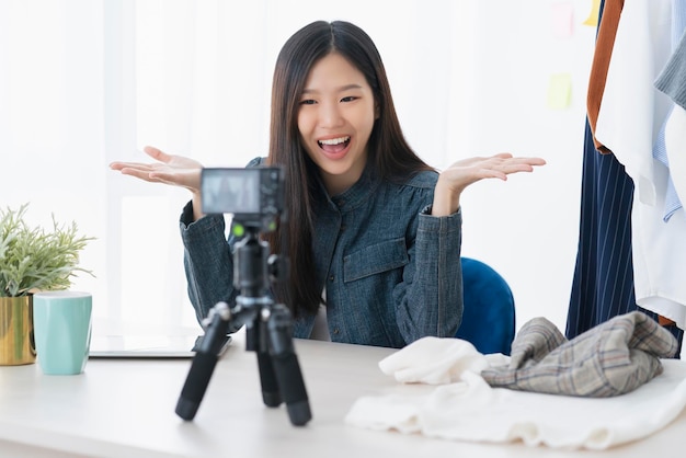 사진 아시아의 아름다운 아시아 블로거 또는 블로거는 옷감 드레스 온라인 비즈니스 상점 온라인 아이디어 개념을 제시합니다.