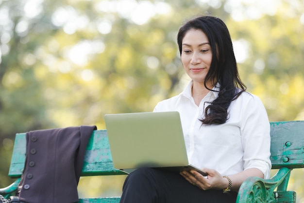 Asian beautiful business woman work relaxation with laptop in park