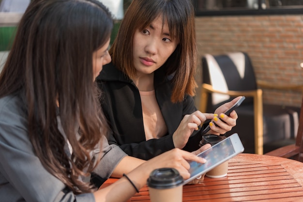 asian  beautiful business woman working with tablet and smartphone in coffee cafe shop 