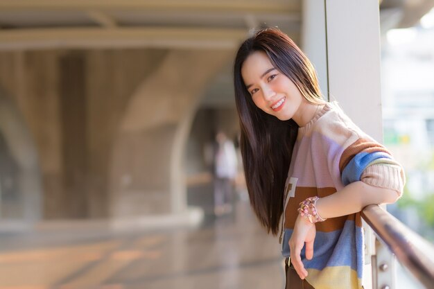 Asian beautiful female in colorful sweater standing to rest from walking in the heat of the city in health care,pollution PM2.5 and new normal concept.