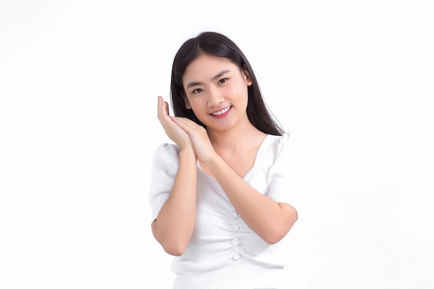 Asian beautiful lady who has long hair smiles and shows her hand near face on white background.