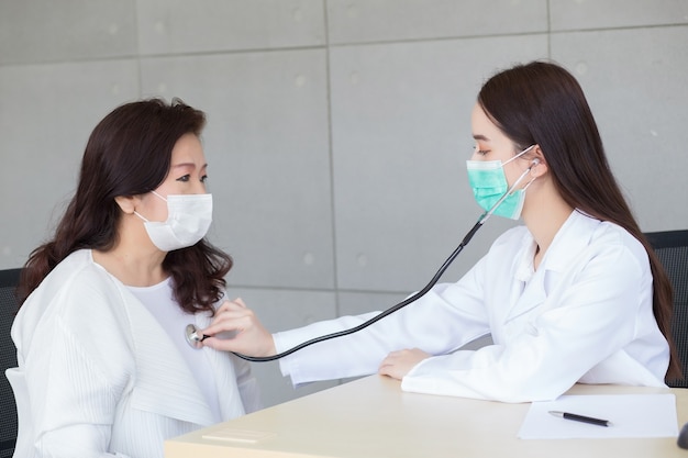 Asian beautiful woman doctor uses stethoscope to check health of lungs  heart or diagnosis symptom