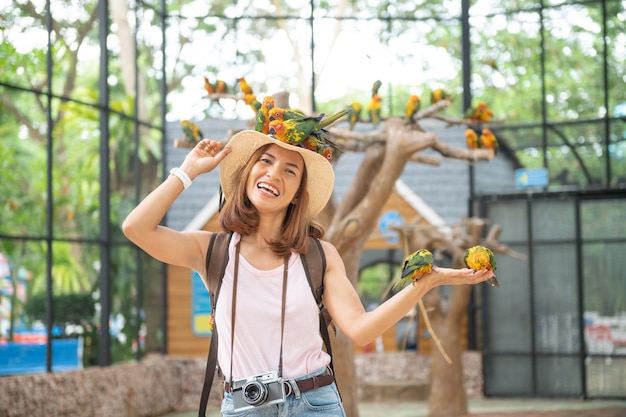 手に愛の鳥と楽しむアジアの美しい女性