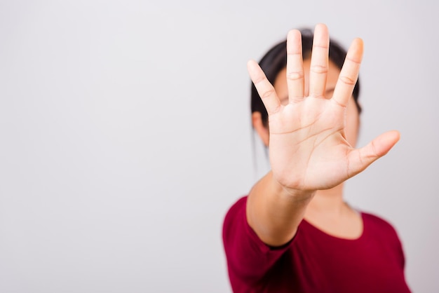 Asian beautiful woman itching her outstretched hand showing stop gesture front face focus