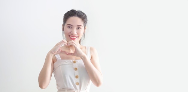 Asian beautiful woman making heart shape symbol by hand in front of her face Valentine's day and Love