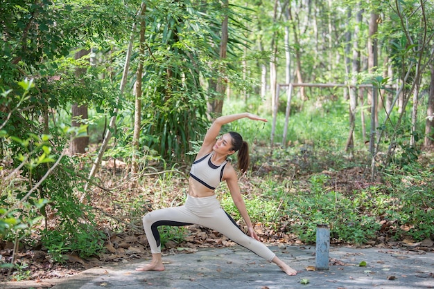 Asian beautiful woman play yoga in the parkThailand people love healthExercise for strong body