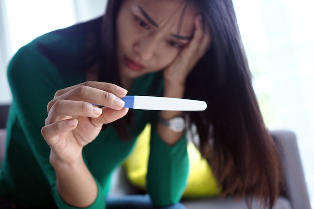 Photo asian beautiful women are stressed and worried about pregnancy results. pregnancy beyond expectations in teenagers