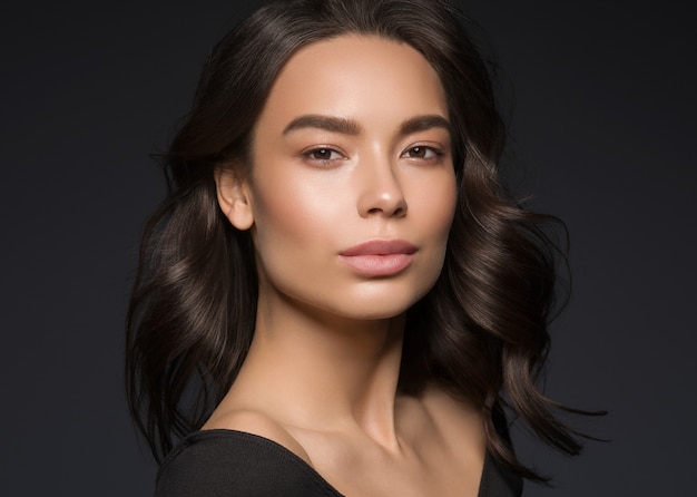 Asian beauty female black background curly black hair natural make up. Studio shot.