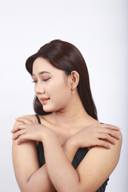 Азиатская красавица, показывающая ее макияж, изолированные на белом фоне