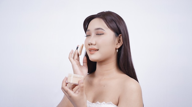 Asian beauty will apply powder isolated on white background