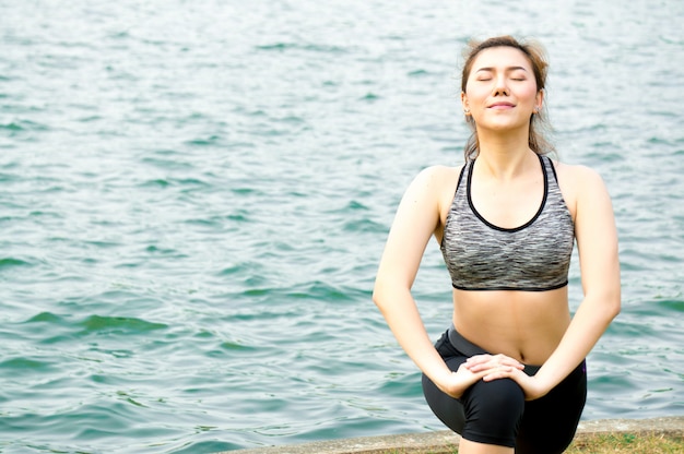 写真 アジアの美しさの女性運動と公園でヨガによるストレッチ