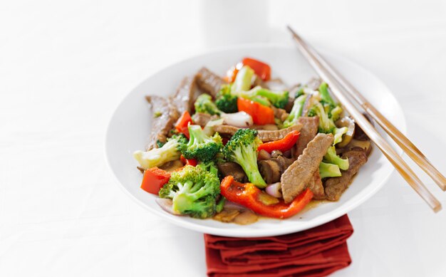 Asian beef stir fry with chopsticks on table