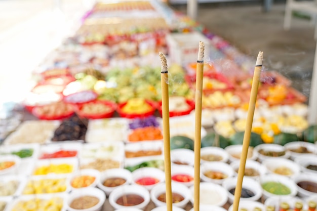 Asian believing, pray with incense and foods.