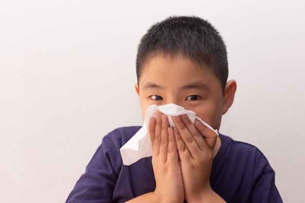 Asian boy cold flu illness tissue blowing runny nose