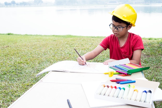 Asian boy coloring in the park