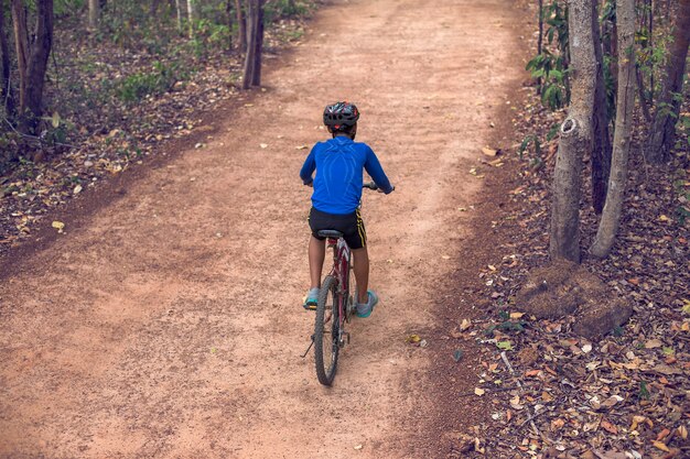 Asian boy cycling on country roads.