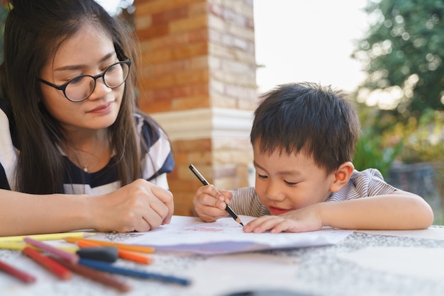 Asian boy drawing and painting with his mother